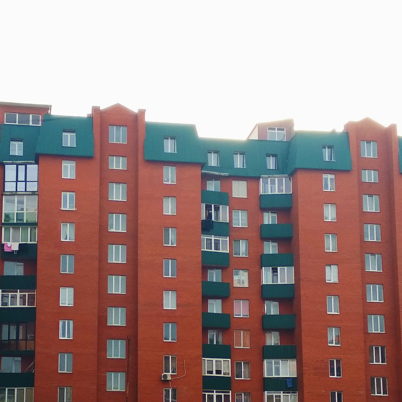 modern block of flats with green roof and balconies